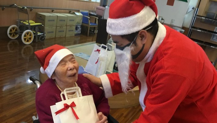 ご利用者さまにプレゼントをお渡しするサンタさん