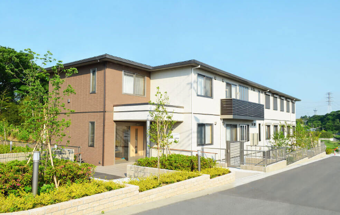介護施設の建物外観。2階建てモダン建築で、煉瓦と白い外壁が特徴。